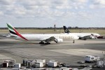 An Emirates Boeing 777-300ER taxis away from T4 and past a TAM Airbus A330 enroute to Dubai.