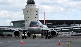 US Airways (N767UW) and Northwest (N371NB) Airbuses taxi to the active at LaGuardia with the classic control tower and Central Termi