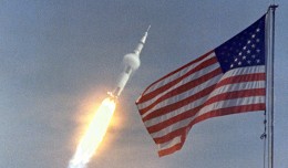 Apollo 11 flies towards earth orbit with the American flag in the foreground. (Photo by NASA)