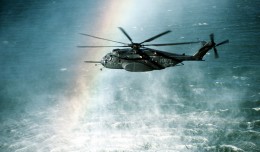 A rainbow is formed in the mist rising from the ocean as a Helicopter Mine Countermeasures Squadron 15 (HM-15) MH-53E Sea Dragon helicopter conducts mine countermeasures operations near Naval Air Station, Alameda, Calif. (Photo by John Gaffney/US Navy)